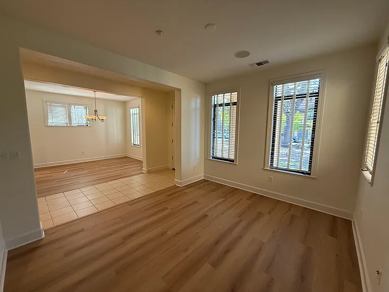 Bright, airy living room and dining room feature large windows, vinyl flooring throughout.
