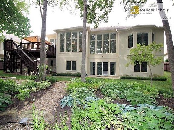 Treed backyard with deck from main level and patio below. Sprinklers to lawn and some drip irrigation and accent lighting in the landscaped yard.