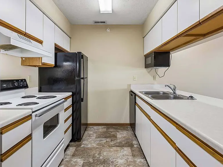 The galley-style kitchen features generous cabinetry, expansive counter space, and an efficient layout designed to make everyday cooking a breeze.