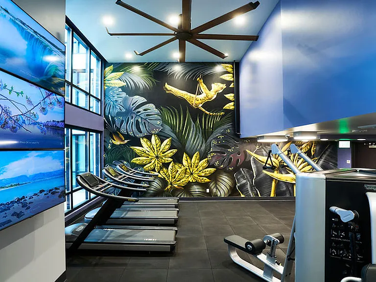 Stunning art mural with HIIT fitness center featuring treadmills and weight stations