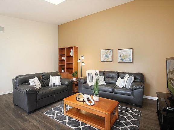 Furnished, spacious living room with soaring ceilings and skylight