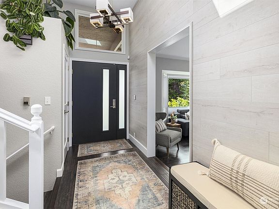A grand entryway with large windows and a modern door sets the tone for the rest of the home>