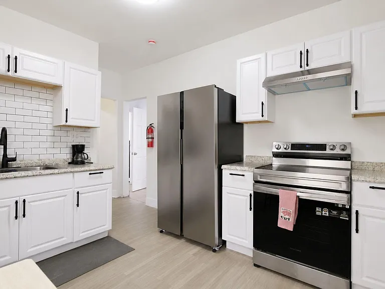 Updated kitchen with white cabinetry, subway-tile backsplash, ample counters, and stainless steel range and refrigerator.