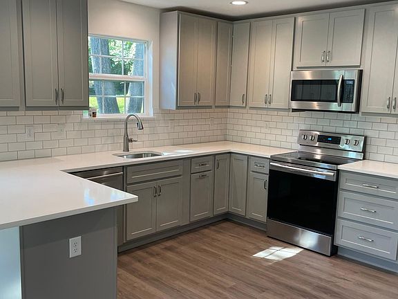 New cabinets, quartz countertops, peninsula that seats three bar stools, stainless steel appliances & subway tile backsplash