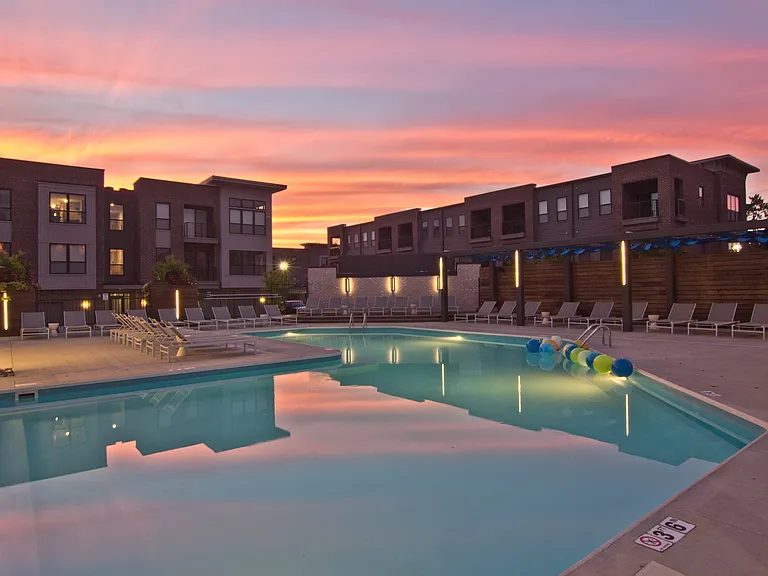 Swimming pool with lounge chairs at dusk