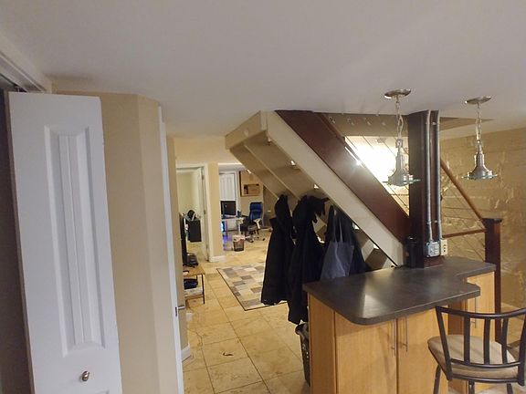 View from entry including kitchen area, living/office area. Ceramic tile or travertine flooring throughout.