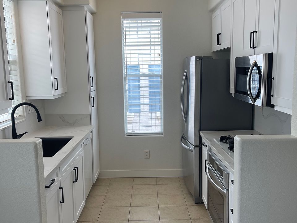 Spacious newly renovated kitchen with stone countertops and backsplash, new cabinets, and stainless appliances.