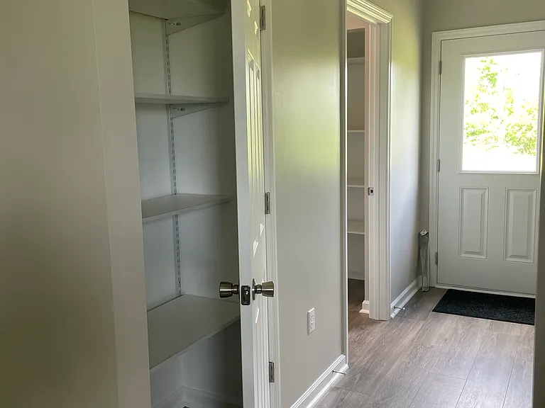 Looking from kitchen into laundry room with pantry, entry into bathroom and back door