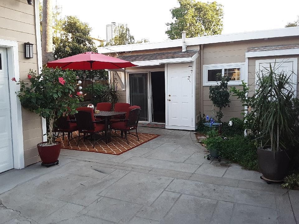 Front patio. Entry way are the sliding glass doors that you see. White door to the right is where the water heater is. Washer/dryer is located in the utility room behind the plants.