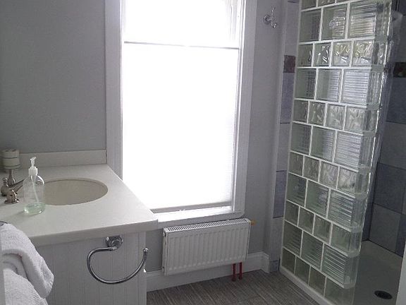 Bathroom to right of kitchen on 2nd floor. Has walk-in shower.