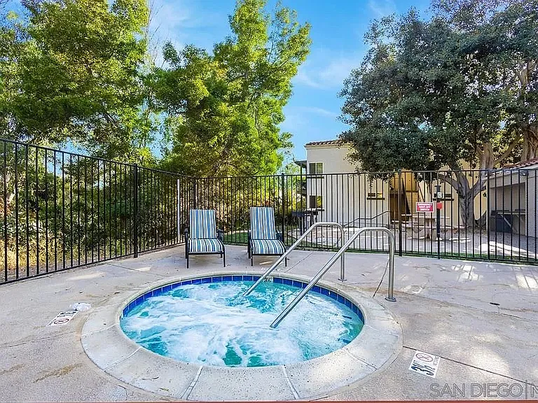 Sparkling swimming pool, hot tub and lounge chairs.