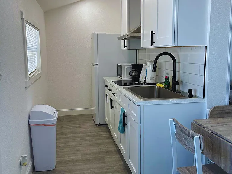 Cozy kitchen equipped with fridge and essential amenities.