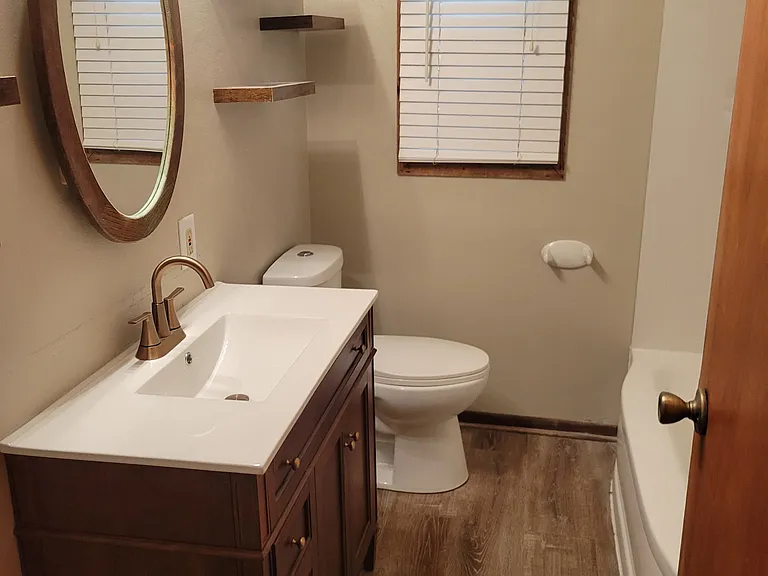 main floor full bathroom with shower over tub & new vanity & LVP flooring