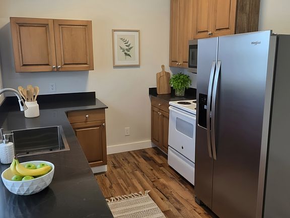 Open kitchen area with lots of storage and solid granite countertops. Stainless steel sink, dw, and fridge.