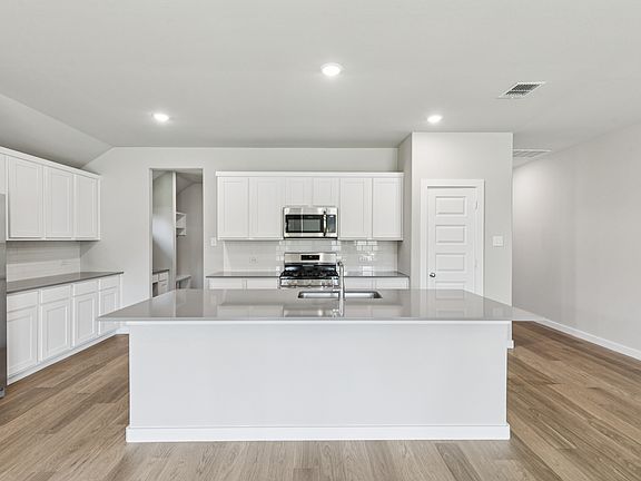 Kitchen in the Heisman home plan by Trophy Signature Homes - REPRESENTATIVE PHOTO