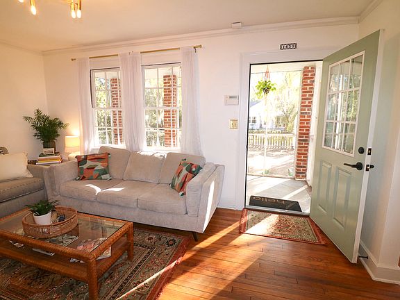 Living room opens up to front screened in porch for relaxed living space, with twin windows for natural light