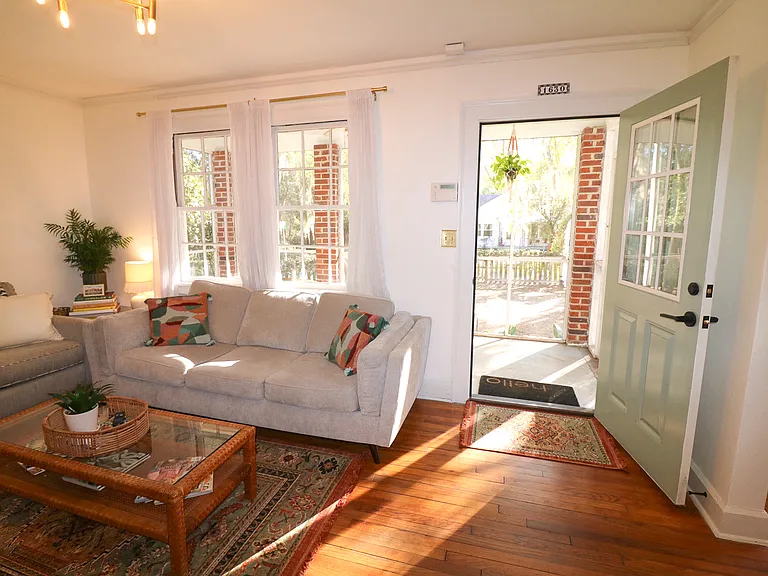 Living room opens up to front screened in porch for relaxed living space, with twin windows for natural light