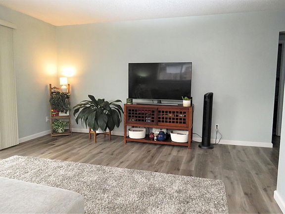 Living room with sliding glass doors on left. Peek into hall bathroom on right of photo.
