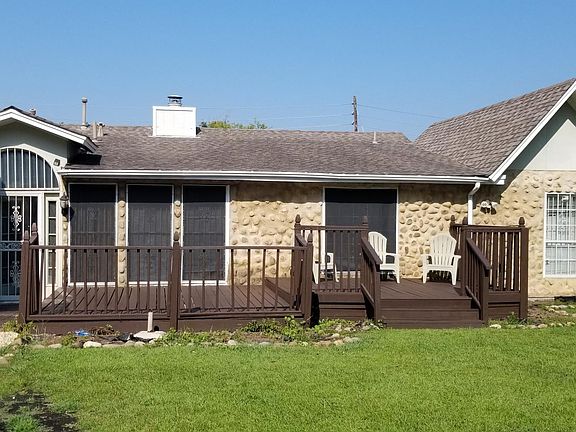 Deck acroos back of house with partial view of screened porch