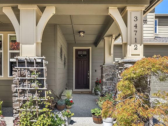 Inviting covered front porch adorned with brick accented columns.