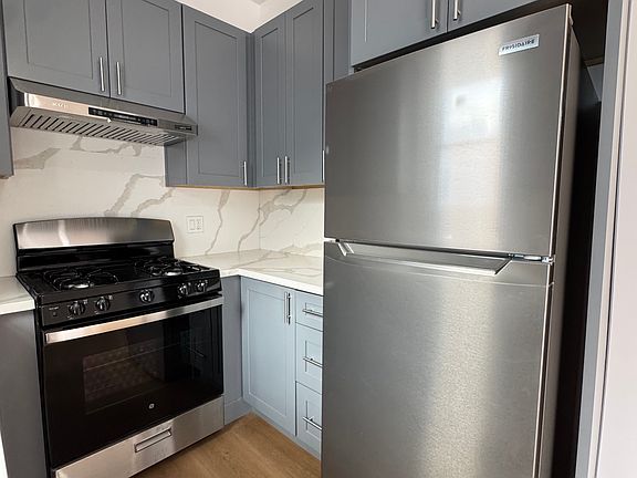 Fully remodeled kitchen with new appliances (dishwasher, range, refrigerator), spacious cabinets, and quartz countertops.