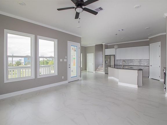 Open plan living (kitchen/living/breakfast), marble look floors and a chef's kitchen. Stainless steel appliances, and loads of cabinets.