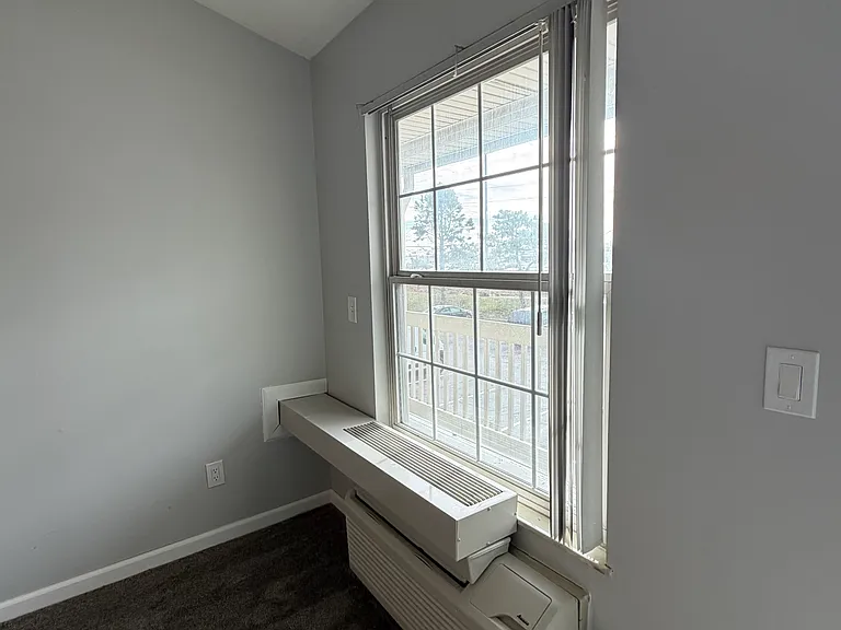 Inside view of living room window and air conditioner.