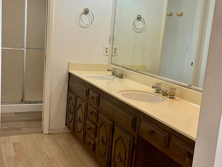 Primary bath vanity area with dual sinks, ample counter space, and an oversized mirror.