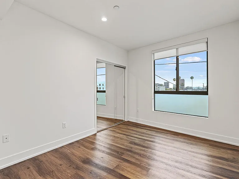 Bedroom with Mirrored Coset, Vinyl Flooring, and Recessed Lighting