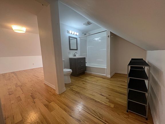 Bathroom with a full bath tub and storage area to the right.