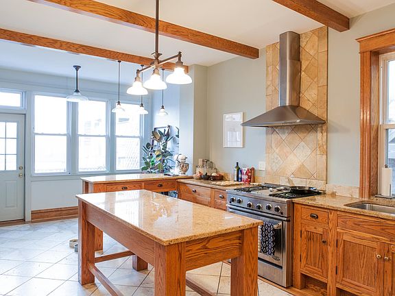 Large kitchen opens to a private North facing 6x10 deck Chef Kitchen with DCS gas stove, hood vented to the outside, double sink, dishwasher, garbage disposal, tile floor, and great lighting