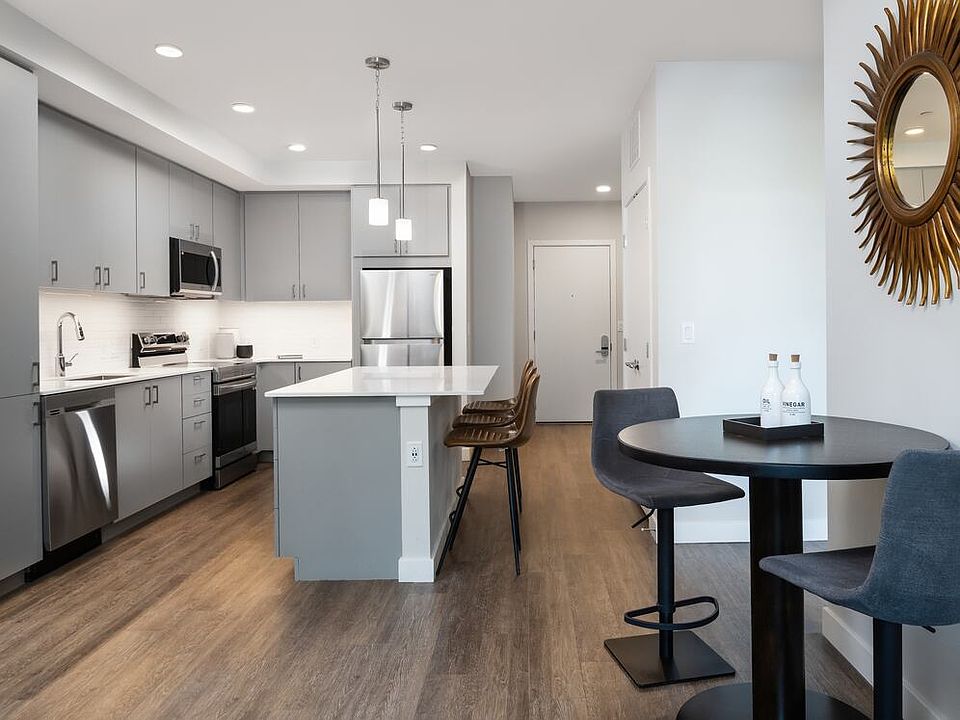 Kitchen, living, and dining areas with hard surface flooring throughout