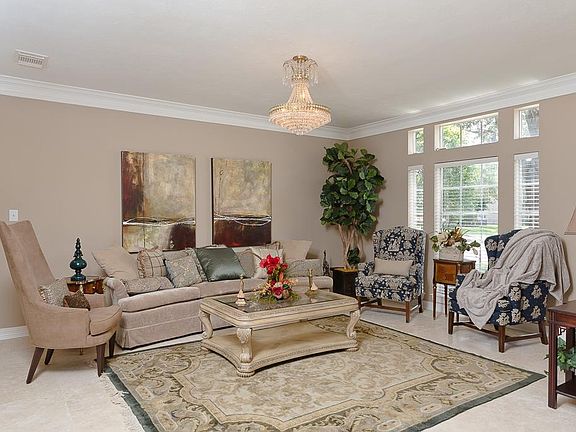 Grand formal living room that features crown molding, an amazing chandelier and new travertine flooring