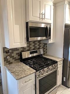 Beautiful stainless steel chef stove, and stainless steel. Microwave oven above the stove.