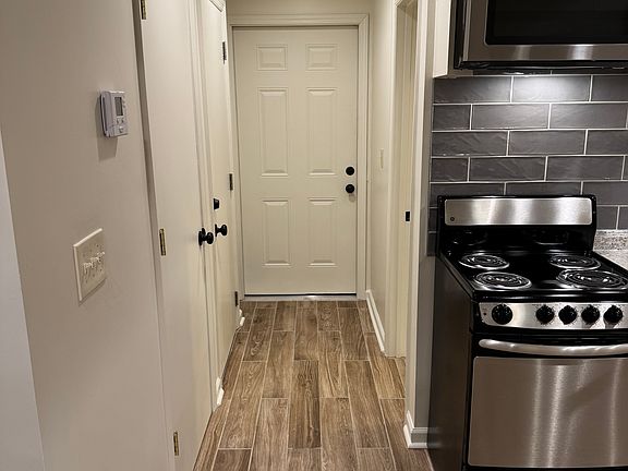 Hallway to entry door and bathroom past kitchen