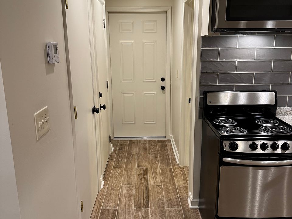 Hallway to entry door and bathroom past kitchen