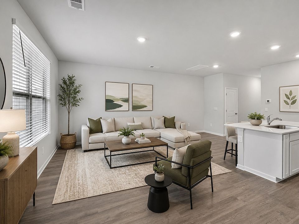Virtually staged image. The open-concept living room and kitchen are located in the rear of the house, allowing for maximum privacy.