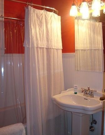 Full bath on first floor features clawfoot tub, beaded board wainscoting 