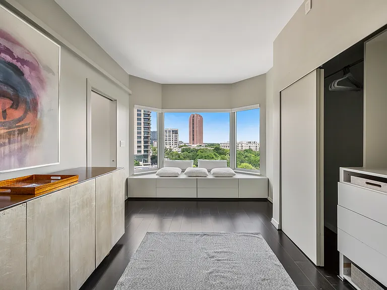 Dedicated dressing area with a window seat, built-in cabinetry, and closet storage.