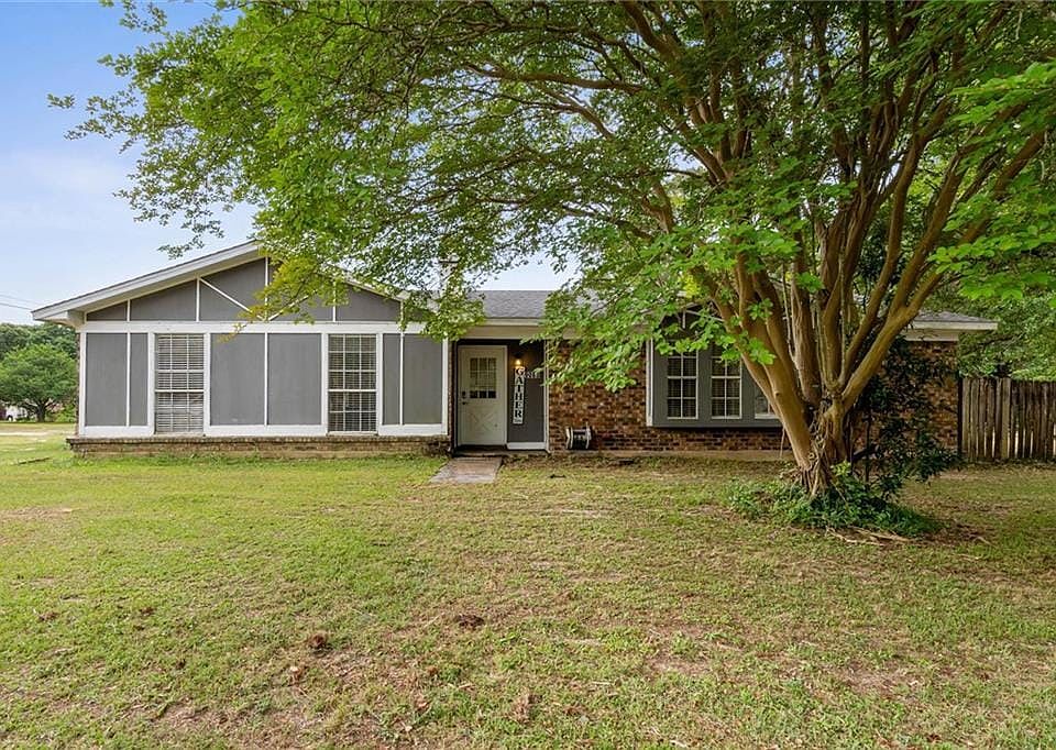 View of front of home with fence, brick siding, and a front yard