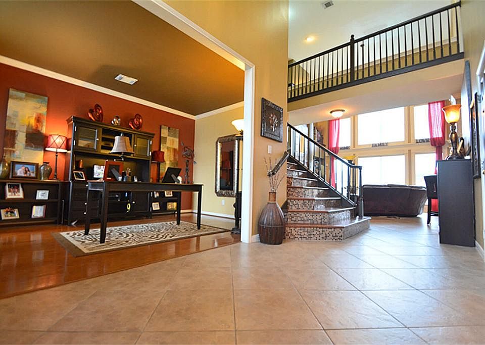 Dramatic Entry with Two Story Ceilings, Sweeping Stairway with Upgraded Wood and amazing Tile Backsplash!  Upgraded Large Tile Floors laid in an Upgraded Pattern!