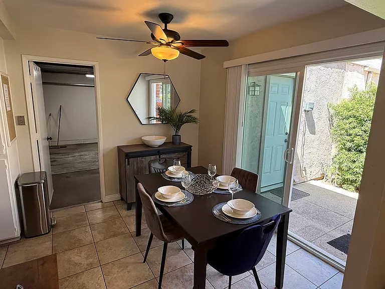 Dining room with access door to garage and sliding door to side patio yard. Patio has additional garage access to laundry.