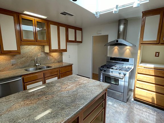Custom kitchen with skylight, granite counter tops, and teak cabinets