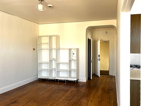 Living room showing the front door and a door to the huge closet on the left. Shelves included but can be removed if preferred.