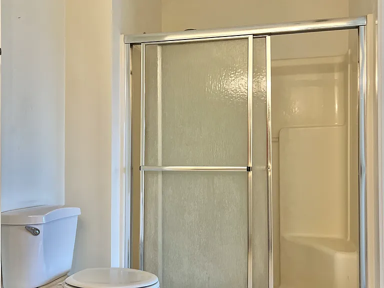 Large en-suite bath with enclosed shower.