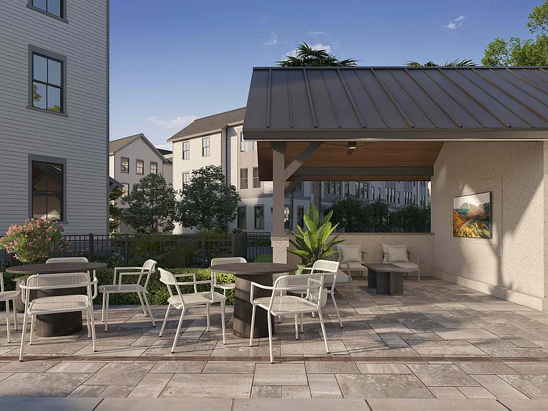 The poolside pavilion at Fenland Townhomes offers shaded seating, tables for gatherings, and a TV for entertainment, creating a perfect retreat by the pool.
