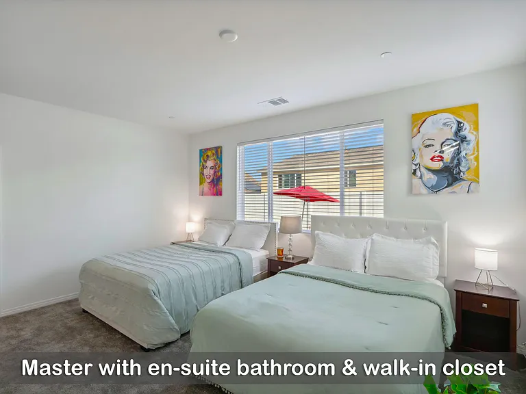 Master bedroom featuring an en-suite bathroom and a spacious walk-in closet.