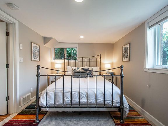 Bedroom with Tempur-Pedic queen mattress and natural light from backyard garden windows