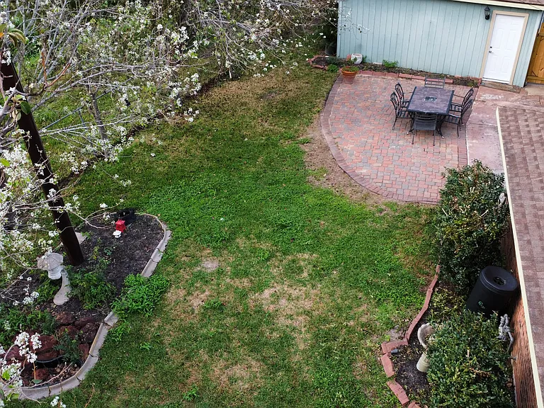 View of patio from roughly the middle of the backyard.