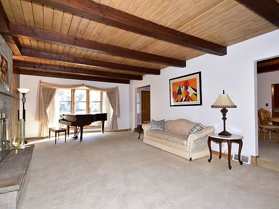 Great Living Room with full wall of custom tongue and groove Ash wood. Generous size of 25' x 15' with wood-beamed ceiling as well!